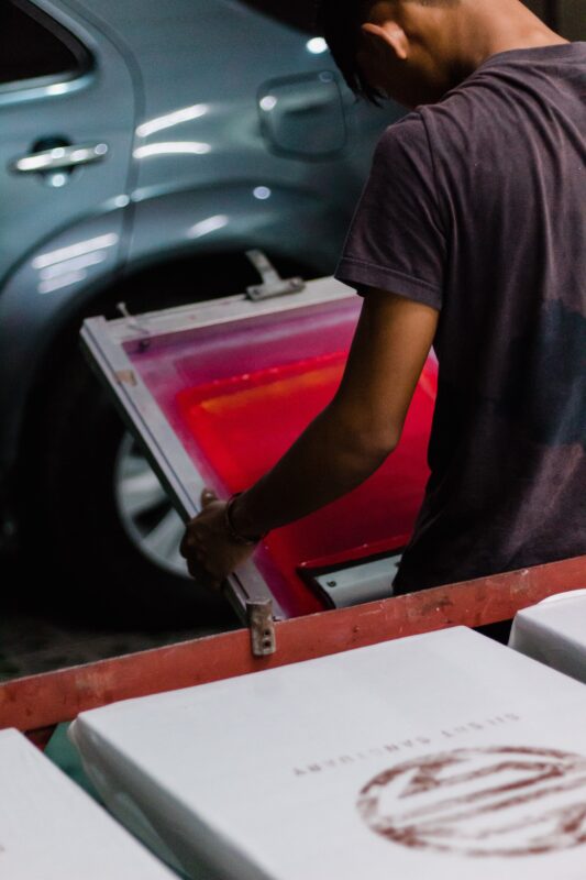 man holding silk screen printing equipment